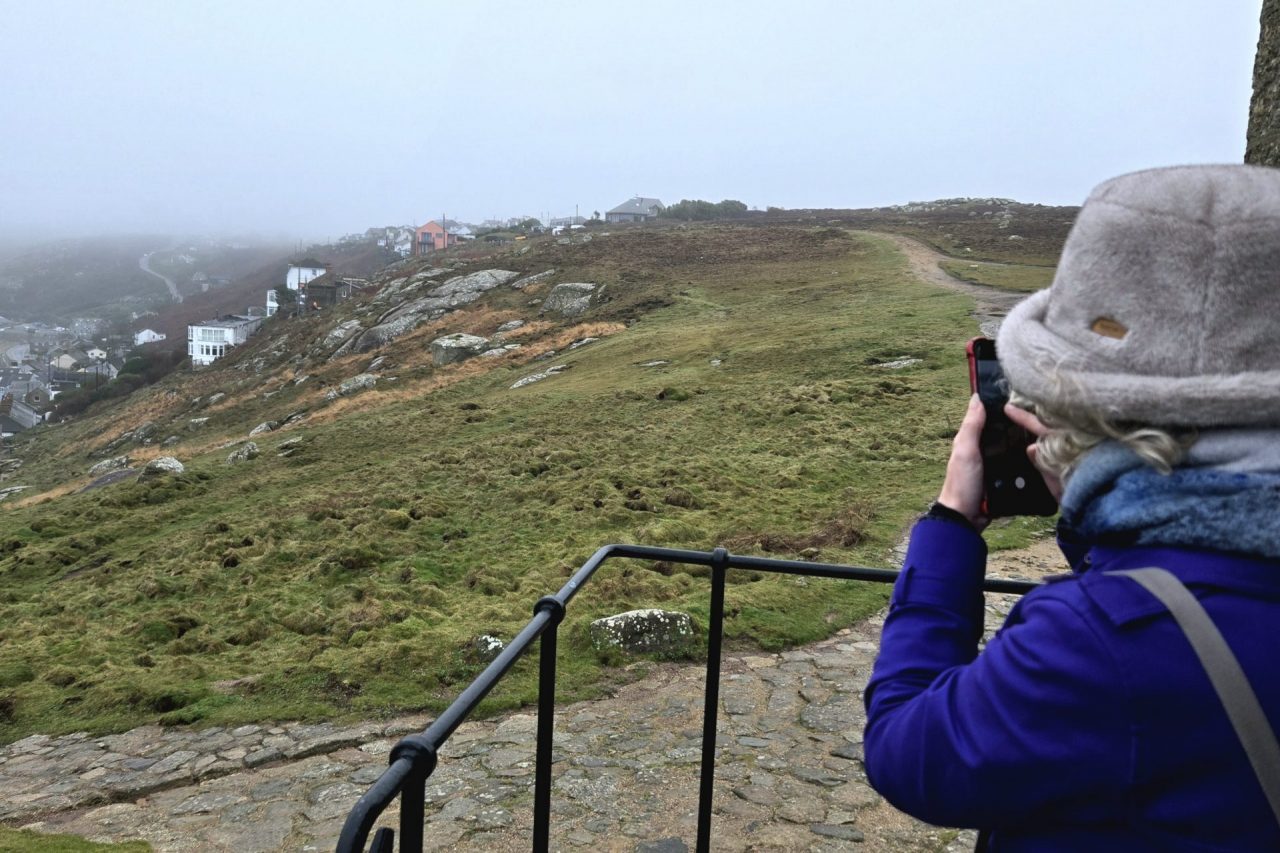 Katie taking photo of the damage at Sennen Cove