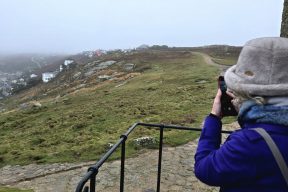 Katie taking photo of the damage at Sennen Cove